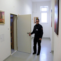 Ein Foto eines Justizvollzugsfachwirtes im Haus 2 beim Öffnen einer Haftraumtür (Zum Artikel zur Schilderung eines Tagesablaufes eines Stationsbeamten)