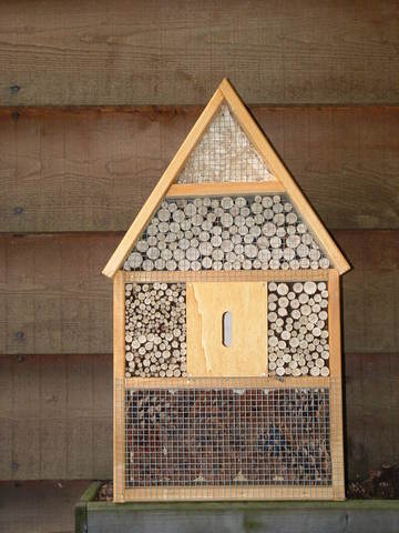 Foto eines Insektenhotels (Zum Artikel Arbeitstherapie/Holzverarbeitung). Suchsymbol Lupe