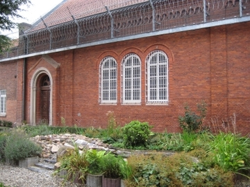 Außenfoto des Einganges zur Kirche mit vorgelagertem Brunnen (Zum Artikel über die Hauptanstalt). Suchsymbol Lupe