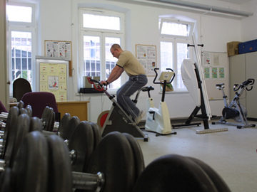 Das Foto zeigt einen Gefangenen im Sportraum, auf einem Cardiogerät (Zum Artikel Sport und Freizeitangebote in der Hauptanstalt). Suchsymbol Lupe