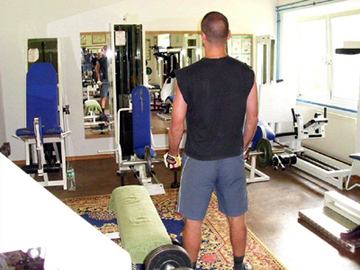 Das Foto zeigt einen Gefangenen im Fitnessraum (Zum Artikel Sport- und Freizeitangebote)