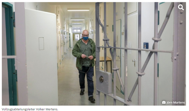 Foto des Vollzugsabteilungsleiters Volker Mertens im Stationsflur. Suchsymbol Lupe