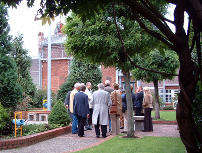Foto einer Besuchergruppe vor dem Sozialhaus auf dem Freistundenhof des Vollzugshauses 2 (Zum Artikel Informationsveranstaltungen)